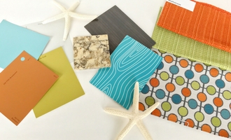 Paint chips, fabric samples and finish boards laid out on a white table
